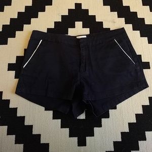 Navy blue shorts with white piping on the pockets.